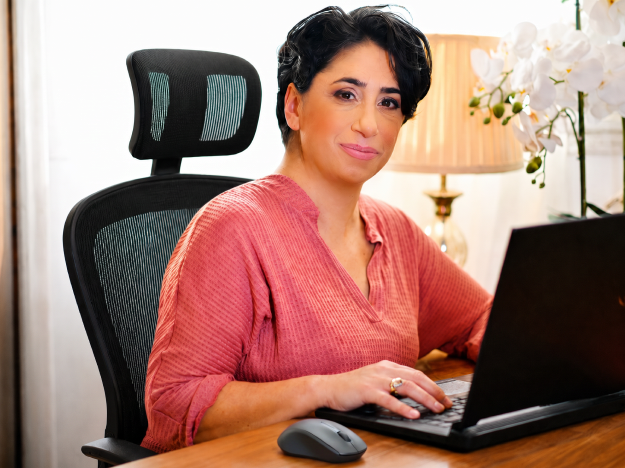 אפרת סטרוזברג יושבת מול לפטופ